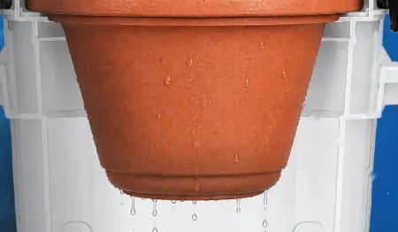Unidad filtrante de arcilla color terracota, con gotas de agua cayendo desde su base
